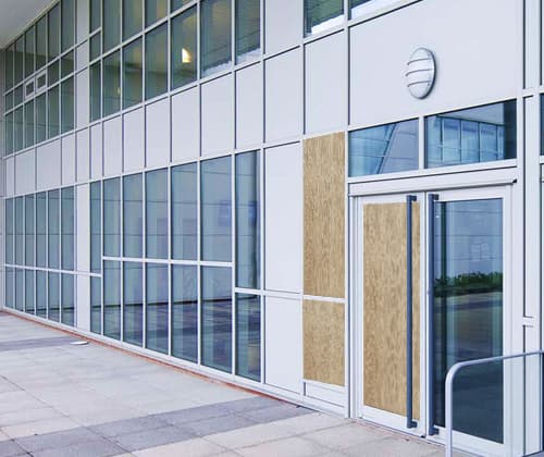 Commercial storefront with emergency board-up before repair